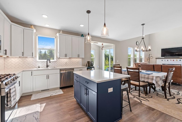 160 Candleberry Ln, Grafton, WI 53024 - kitchen featuring appliances with stainless steel finishes, a sink, decorative backsplash, light wood finished floors, and light countertops