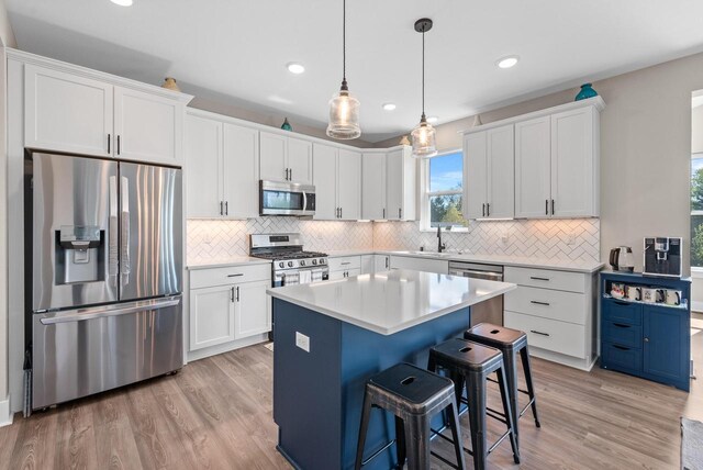 160 Candleberry Ln, Grafton, WI 53024 - kitchen featuring appliances with stainless steel finishes, a breakfast bar, backsplash, light wood-type flooring, and recessed lighting