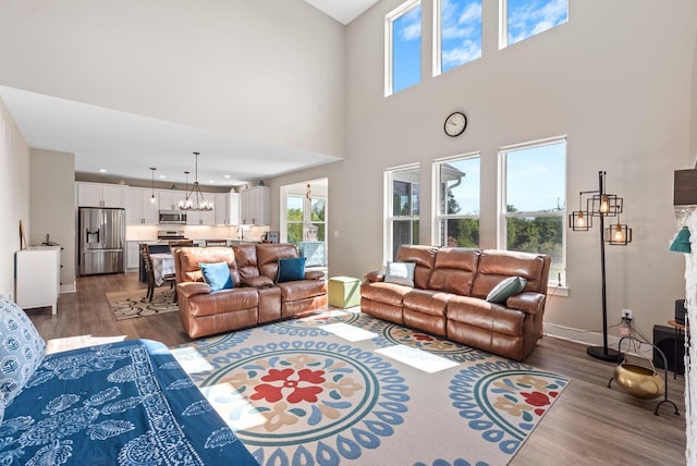 160 Candleberry Ln, Grafton, WI 53024 - living room with a chandelier, dark wood-type flooring, baseboards, and a towering ceiling