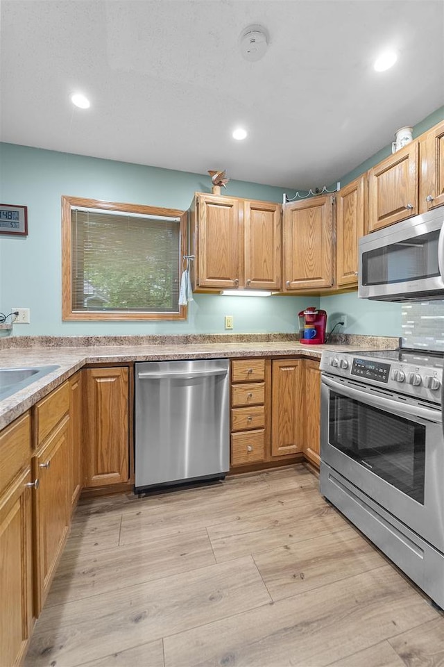 W5204 N Osprey Dr, New Lisbon, WI 53950 - kitchen with stainless steel appliances, light wood-style floors, recessed lighting, light countertops, and a sink