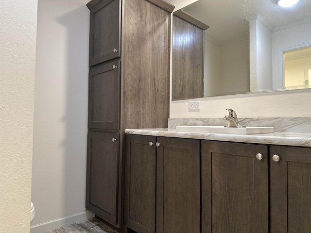 32793 Fulton St, Gotham, WI 53540 - bathroom with toilet, vanity, ornamental molding, wood finished floors, and baseboards