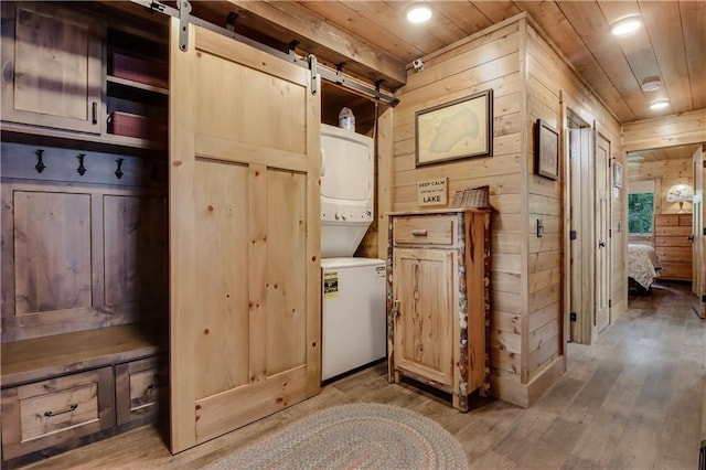 14856W Valhalla Dr, Hayward, WI 54843 - laundry area with estacked washer and dryer, wood walls, wood ceiling, a barn door, and wood finished floors