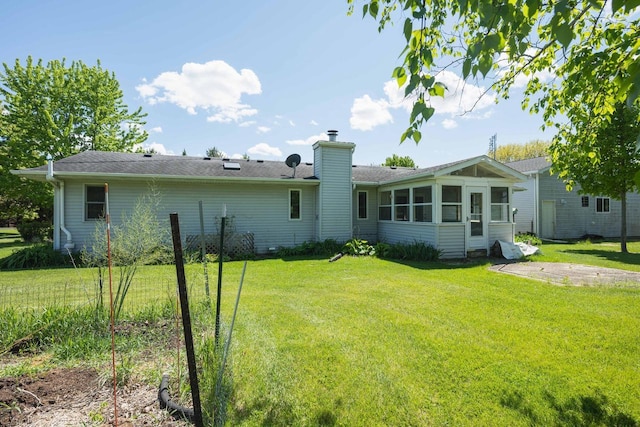 W5670 School Rd, Walworth, WI 53184 - back of house featuring a chimney, a sunroom, and a lawn