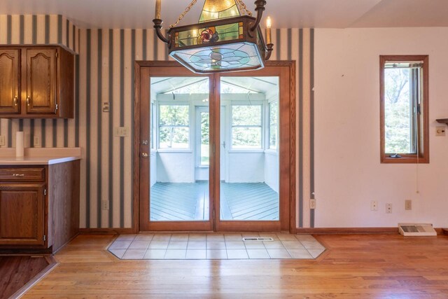 W5670 School Rd, Walworth, WI 53184 - doorway to outside featuring light wood-type flooring, baseboards, healthy amount of natural light, and wallpapered walls