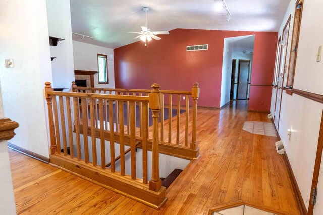 W5670 School Rd, Walworth, WI 53184 - hallway with an upstairs landing, hardwood / wood-style floors, lofted ceiling, rail lighting, and baseboards