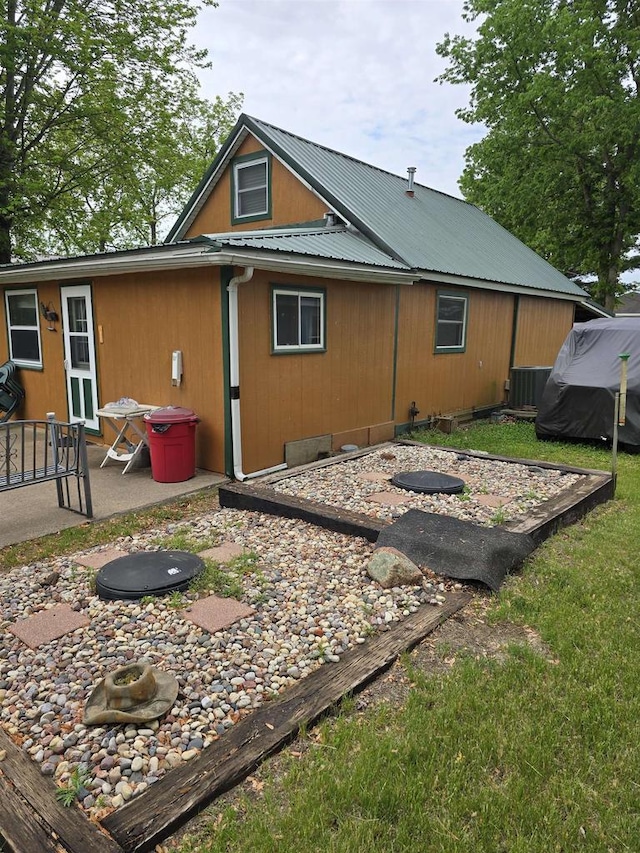 Pine Ln, Bloomington, WI 53804 - back of property with a patio area, metal roof, central AC unit, and a lawn