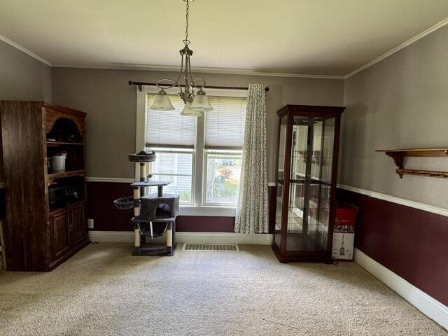 219 E 9th St, Fond Du Lac, WI 54935 - dining area featuring a chandelier, carpet, crown molding, and baseboards