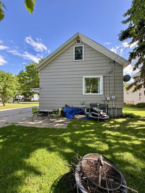 219 E 9th St, Fond Du Lac, WI 54935 - rear view of property with a lawn, a patio, and an outdoor fire pit