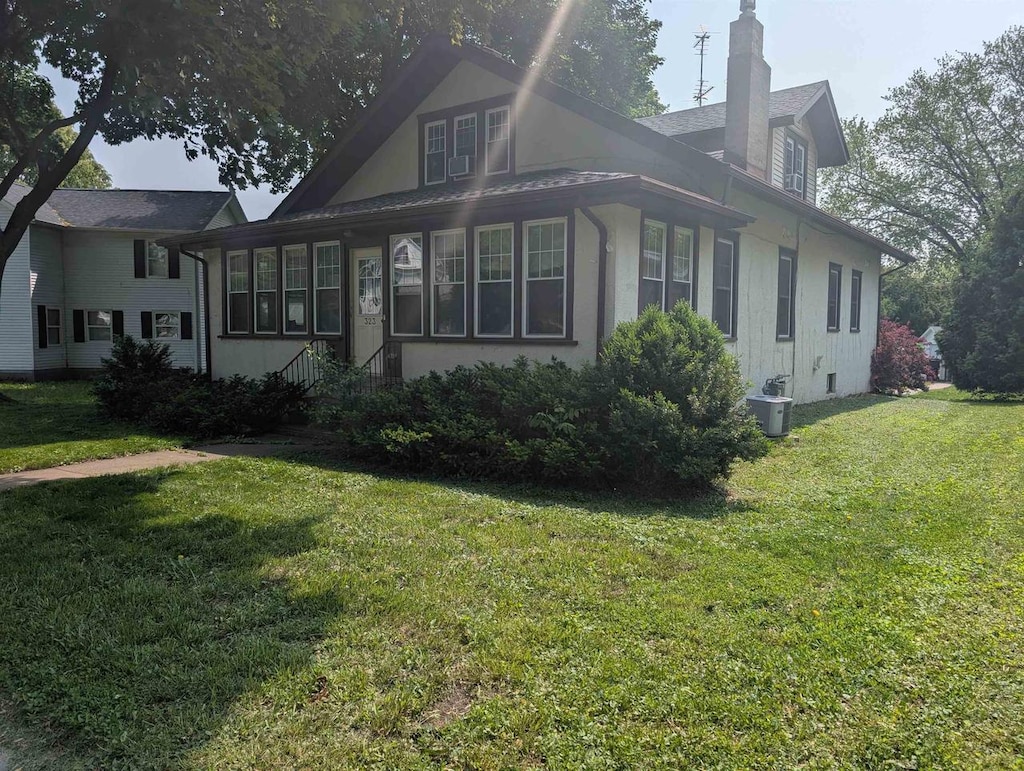 323 S Janesville St, Whitewater, WI 53190 - view of side of property featuring a chimney and a yard