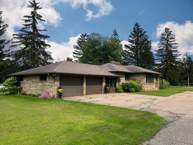 4211 State Highway 173, Nekoosa, WI 54457 - view of front of home with an attached garage, a front yard, a chimney, concrete driveway, and brick siding