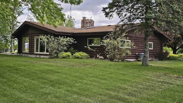 W12269 Sunny Knoll Rd, Brandon, WI 53919 - rear view of house featuring log exterior, a chimney, a yard, and a shingled roof