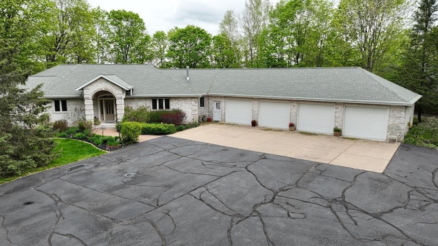 W11078 S Shore Rd, Deerbrook, WI 54425 - single story home featuring driveway, view of wooded area, a shingled roof, and an attached garage