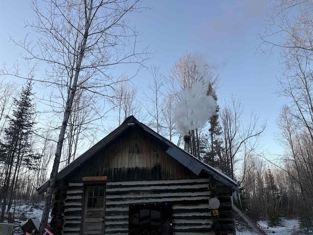 72884 Mertig Rd, Glidden, WI 54527 - view of snowy exterior featuring log exterior, a barn, and an outdoor structure
