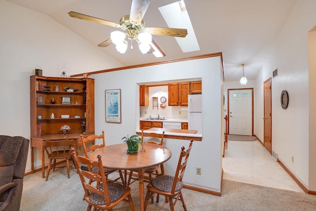 741 Kensington Sq, Stoughton, WI 53589 - dining room with light carpet, vaulted ceiling, a skylight, ceiling fan, and baseboards