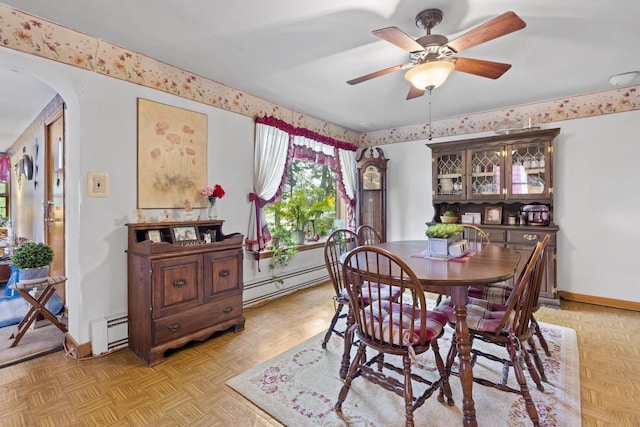 W156N8813 Pilgrim Rd, Menomonee Falls, WI 53051 - dining space featuring a baseboard heating unit, arched walkways, ceiling fan, and baseboards