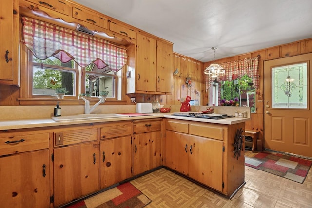 W156N8813 Pilgrim Rd, Menomonee Falls, WI 53051 - kitchen with a sink, gas cooktop, healthy amount of natural light, a chandelier, and wood walls