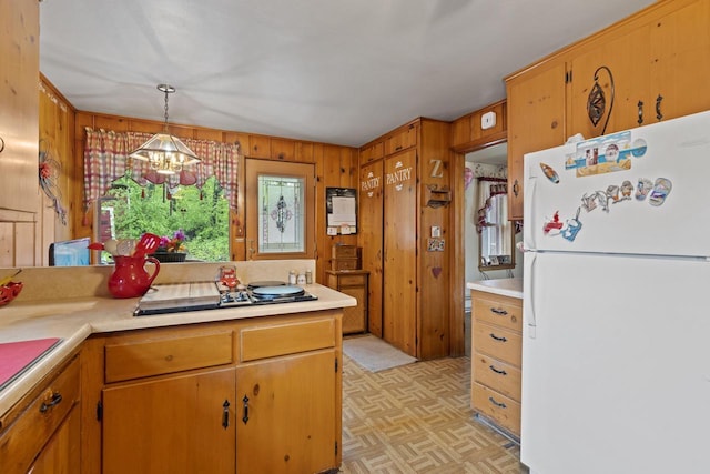 W156N8813 Pilgrim Rd, Menomonee Falls, WI 53051 - kitchen featuring freestanding refrigerator, light countertops, a chandelier, wooden walls, and black electric cooktop