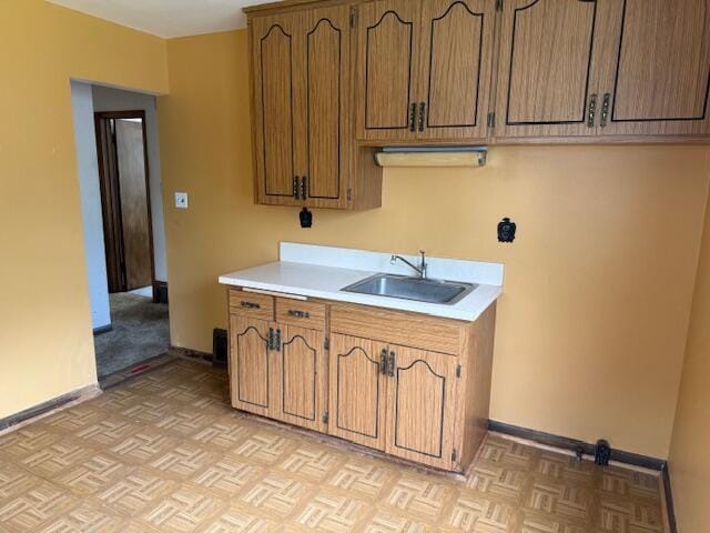 424 S 66th St, Milwaukee, WI 53214 - kitchen featuring a sink, light countertops, baseboards, and brown cabinets