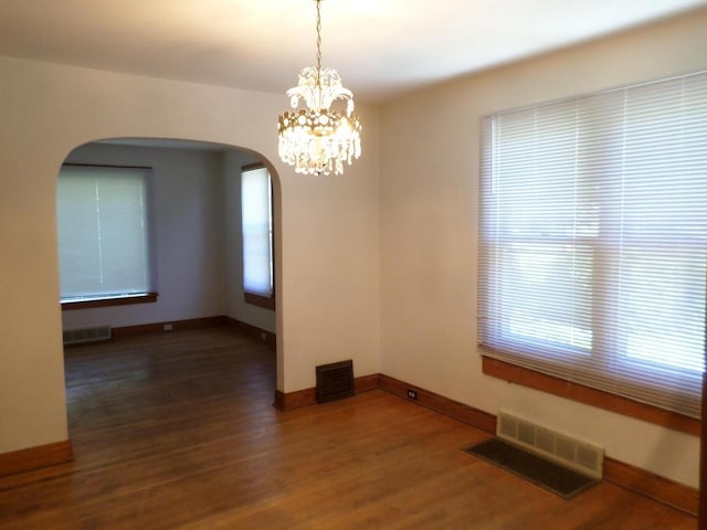 1909 91st St, Pleasant Prairie, WI 53158 - unfurnished room with arched walkways, wood finished floors, baseboards, and a chandelier