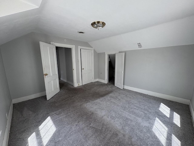 41 E 9th St, Fond Du Lac, WI 54935 - additional living space with dark carpet, vaulted ceiling, and baseboards