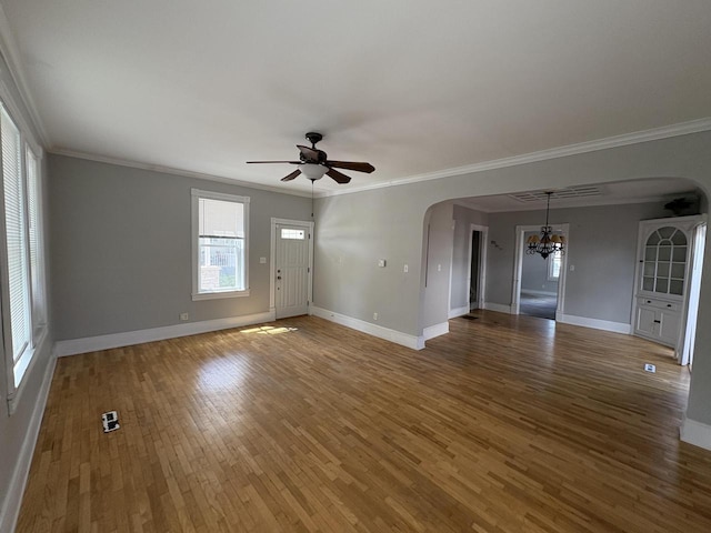 41 E 9th St, Fond Du Lac, WI 54935 - unfurnished living room featuring arched walkways, a chandelier, a ceiling fan, wood finished floors, and baseboards