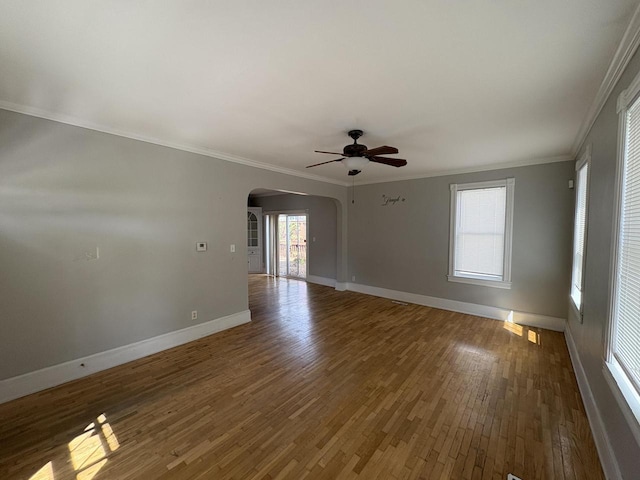 41 E 9th St, Fond Du Lac, WI 54935 - unfurnished room featuring arched walkways, ceiling fan, wood finished floors, baseboards, and ornamental molding