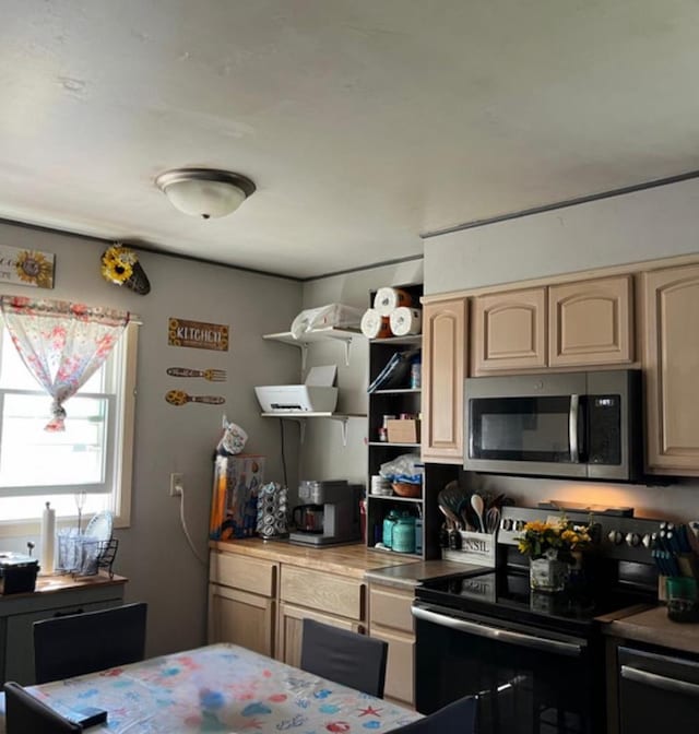 429 Pine St, Tomah, WI 54660 - kitchen with black electric range, stainless steel microwave, open shelves, and dishwashing machine