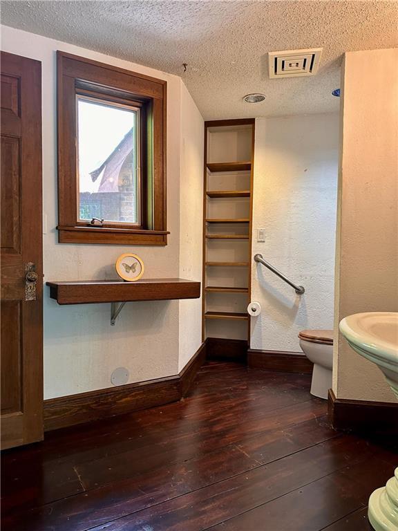 16680W Raining Tree Rd, Stone Lake, WI 54876 - bathroom featuring hardwood / wood-style floors, toilet, vanity, baseboards, and a textured ceiling