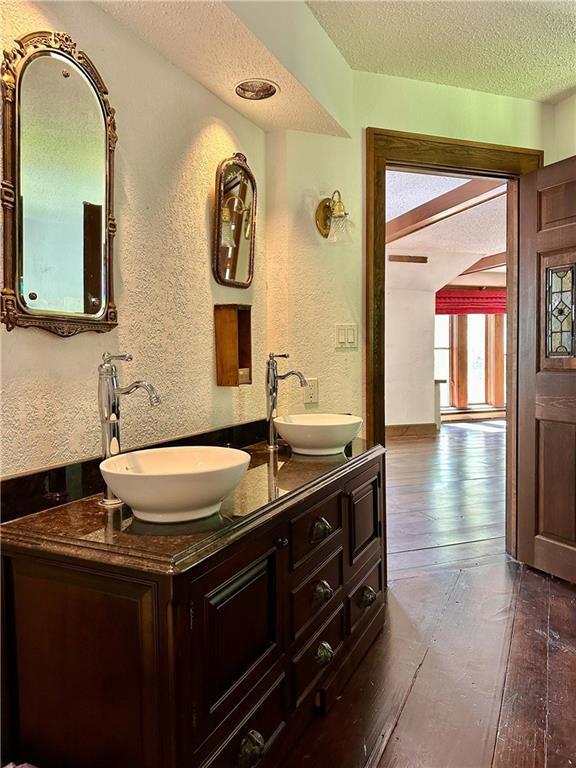 16680W Raining Tree Rd, Stone Lake, WI 54876 - bathroom featuring a textured ceiling, hardwood / wood-style flooring, a textured wall, and double vanity