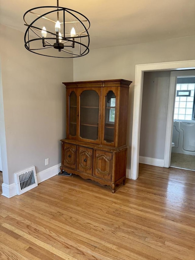 4717 N 19th St, Milwaukee, WI 53209 - unfurnished dining area with a chandelier, baseboards, and light wood-style flooring