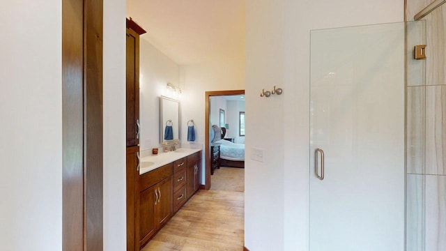 W10559 Hickory Point Rd, Beaver Dam, WI 53916 - ensuite bathroom featuring double vanity, a stall shower, and wood finished floors