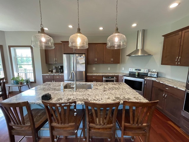 W10559 Hickory Point Rd, Beaver Dam, WI 53916 - kitchen with wall chimney range hood, appliances with stainless steel finishes, a sink, an island with sink, and recessed lighting