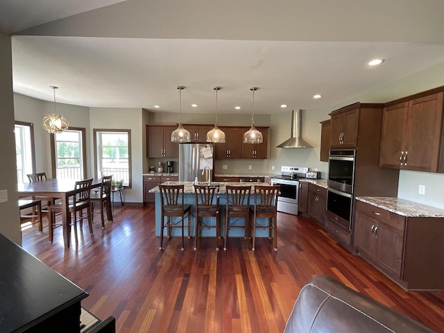 W10559 Hickory Point Rd, Beaver Dam, WI 53916 - kitchen featuring stainless steel appliances, wall chimney exhaust hood, recessed lighting, dark wood-style flooring, and a breakfast bar area