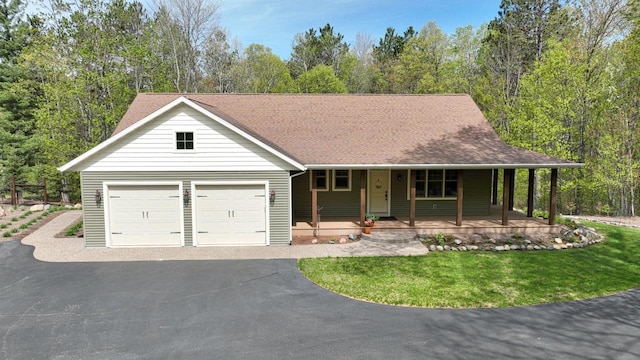 6383 Northwestern Dr, Rhinelander, WI 54501 - view of front of home featuring covered porch, asphalt driveway, an attached garage, and a shingled roof