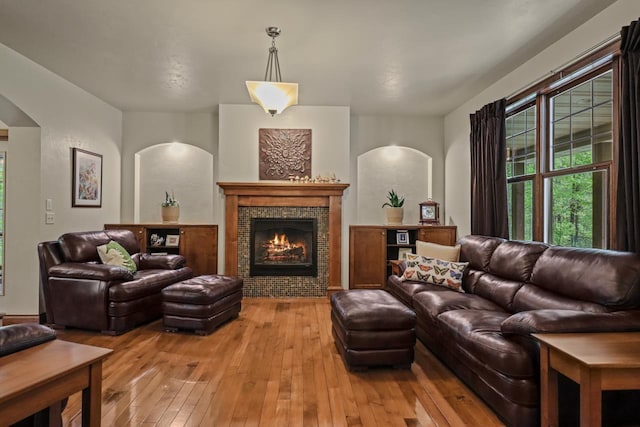 6383 Northwestern Dr, Rhinelander, WI 54501 - living area featuring light wood finished floors, a tile fireplace, and arched walkways