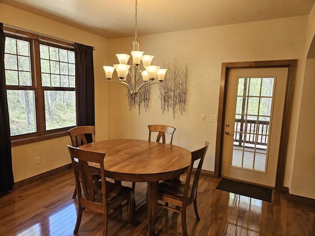 6383 Northwestern Dr, Rhinelander, WI 54501 - dining area featuring dark wood-style floors, a chandelier, and baseboards