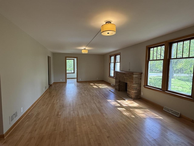 3400 Vine St, Stevens Point, WI 54481 - unfurnished living room with light wood-style flooring, baseboards, and a stone fireplace