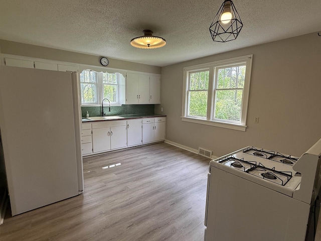 3400 Vine St, Stevens Point, WI 54481 - kitchen with white appliances, a sink, white cabinets, a textured ceiling, and light wood-type flooring
