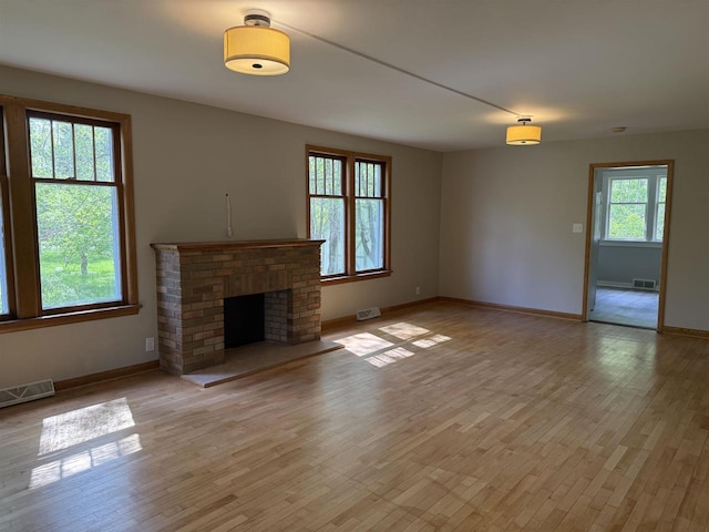 3400 Vine St, Stevens Point, WI 54481 - unfurnished living room with baseboards, light wood-type flooring, and a brick fireplace