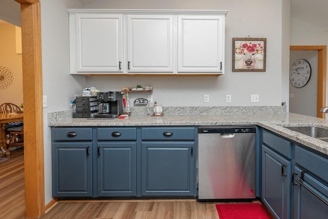 217 Steeple Ct, Johnson Creek, WI 53038 - kitchen featuring stainless steel dishwasher, blue cabinetry, light wood-style floors, a sink, and white cabinetry