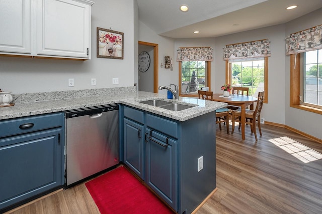 217 Steeple Ct, Johnson Creek, WI 53038 - kitchen with stainless steel dishwasher, blue cabinetry, a sink, light wood-type flooring, and white cabinetry