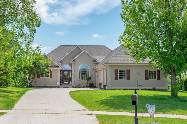217 Steeple Ct, Johnson Creek, WI 53038 - view of front of house featuring roof with shingles, a front yard, driveway, and stucco siding