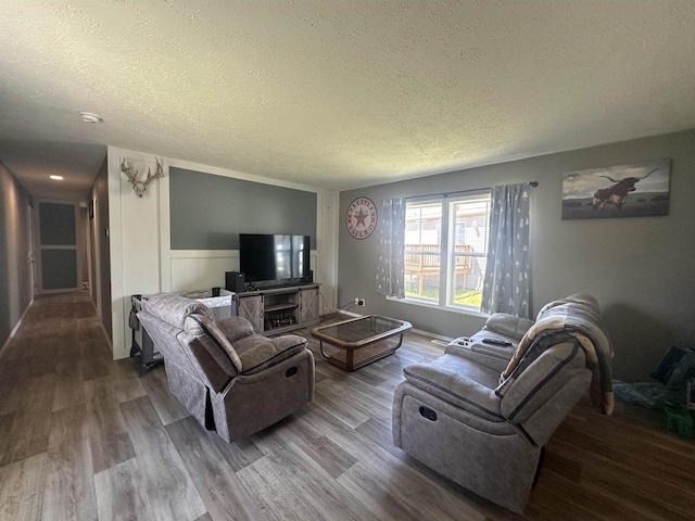 916 S Madison St Unit 9, Waupun, WI 53963 - living area featuring a textured ceiling, wood finished floors, and a wainscoted wall