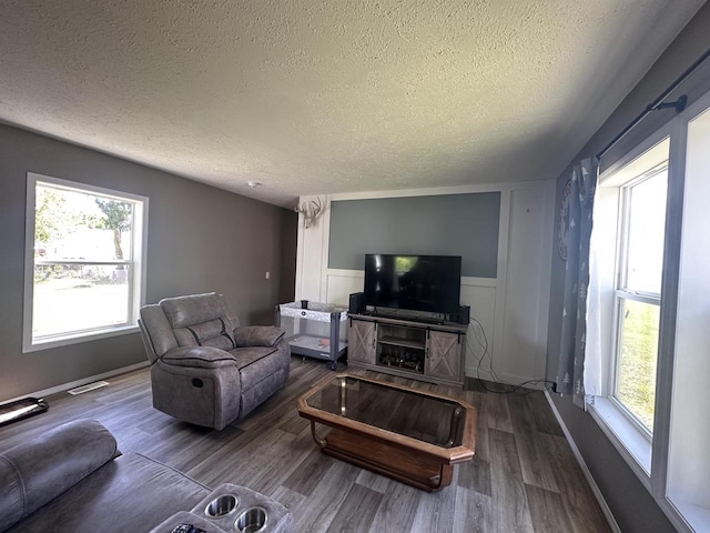 916 S Madison St Unit 9, Waupun, WI 53963 - living room featuring a textured ceiling, wood finished floors, and a wainscoted wall