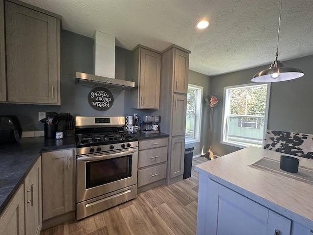 916 S Madison St Unit 9, Waupun, WI 53963 - kitchen featuring gas range, wall chimney range hood, a textured ceiling, light wood-style floors, and pendant lighting