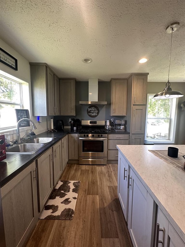 916 S Madison St Unit 9, Waupun, WI 53963 - kitchen with wall chimney exhaust hood, stainless steel gas stove, a sink, a textured ceiling, and dark wood-style floors