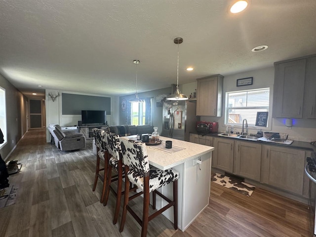916 S Madison St Unit 9, Waupun, WI 53963 - kitchen with a sink, dark wood-style floors, gray cabinetry, a kitchen breakfast bar, and stainless steel refrigerator with ice dispenser