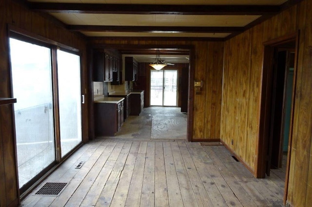 1305 La Crescent St, La Crosse, WI 54603 - kitchen with beam ceiling, light countertops, wooden walls, and light wood-type flooring