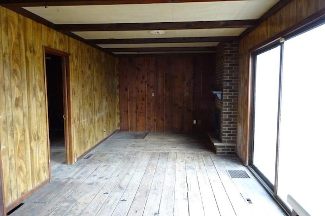 1305 La Crescent St, La Crosse, WI 54603 - spare room with beam ceiling, wooden walls, and light wood-type flooring