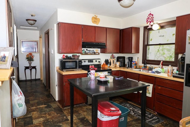 1133 Smith Ave, Antigo, WI 54409 - kitchen with under cabinet range hood, appliances with stainless steel finishes, stone finish floors, and light countertops
